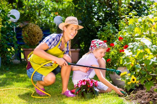 Operative using appropriate PPE while trimming hedges